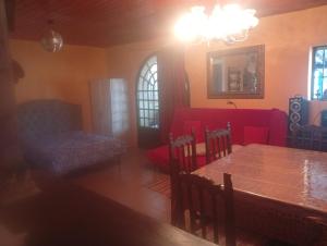 a living room with a table and a red couch at Elena's bar loft in Poio