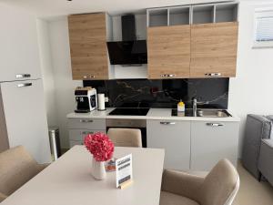 a kitchen with a table with a vase of flowers on it at Ana Deluxe Apartment in Radovljica