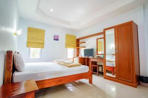 a bedroom with a bed and a desk and a mirror at เก็บตะวัน รีสอร์ท in Ban Hua Khao Sammuk