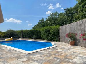 a swimming pool in a backyard with a fence and trees at Guesthouse Vionica - Peace & Pool in Međugorje