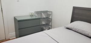 a bedroom with a glass cabinet next to a bed at E3 Hostings in Hamilton