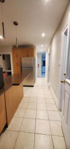 an empty kitchen with a counter and a refrigerator at E3 Hostings in Hamilton