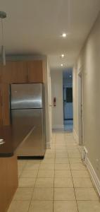an empty kitchen with a stainless steel refrigerator at E3 Hostings in Hamilton