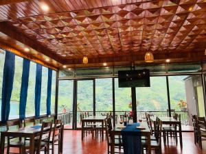 a restaurant with tables and chairs and a flat screen tv at TaVan Eco Home in Tả Van +35 photos