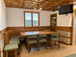 a dining room with a wooden table and chairs at Mohoričeva domačija in Idrija