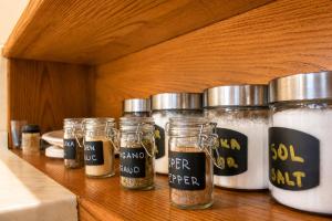 a row of jars of spices on a wooden shelf at Mohoričeva domačija in Idrija +19 photos