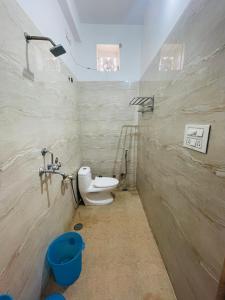 a bathroom with a toilet and a blue bucket at Vedsa haveli new in Udaipur