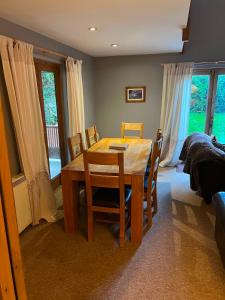 a dining room with a wooden table and chairs at The Wicket Cottage in Burlescombe