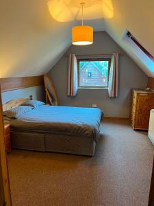 a bedroom with a bed and a window at The Wicket Cottage in Burlescombe