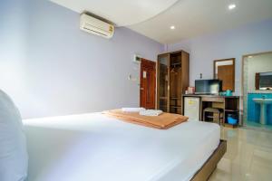 a bedroom with a white bed and a kitchen at เก็บตะวัน รีสอร์ท in Ban Hua Khao Sammuk +1 photo