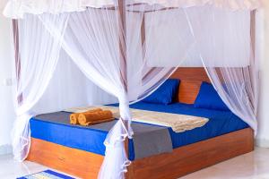 a bedroom with a bed with a canopy at Rainforest Soul Villa in Mederipitiya