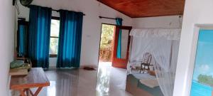 a room with blue curtains and a room with a crib at Rainforest Soul Villa in Mederipitiya