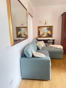 a living room with a blue couch and a mirror at Marina Panoramic Sea View in Scalea +25 photos