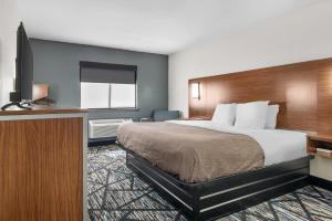 a hotel room with a bed and a flat screen tv at Quality Inn Cedartown in Cedartown