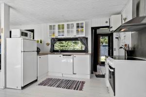 a kitchen with white appliances and a window at 8804-Glesborg-Vesttoften-20 in Glesborg +18 photos