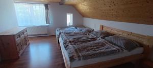 a bedroom with two beds and a wooden ceiling at Chalupa Krbálka in Jeseník