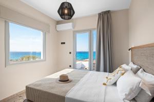 a bedroom with a bed with a view of the ocean at Studios Kontos in Mikri Vigla