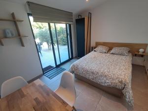 a bedroom with a bed and a table and chairs at Escapade à Saint-Saturnin-les-Avignon in Jonquerettes