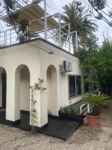 a white building with arches and plants in a yard at La casa di Giulia in Genoa +8 photos