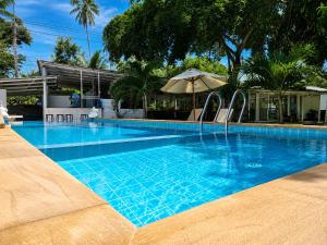 a large blue swimming pool with an umbrella at Villa Giacomelli Samui in Taling Ngam Beach