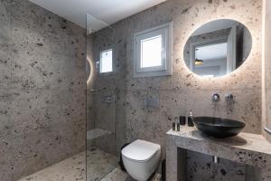 a bathroom with a sink and a toilet and a mirror at Studios Kontos in Mikri Vigla +124 photos