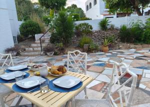 a wooden table with plates of food on a patio at Apartament Maria F in Mojácar