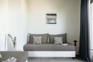 a couch sitting in a living room next to a window at Bella Vista Hotel "by Checkin" in Hersonissos +41 photos