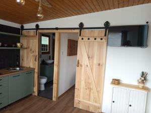 a bathroom with a wooden door and a toilet at Sóz-Lak in Mezőcsát +4 photos