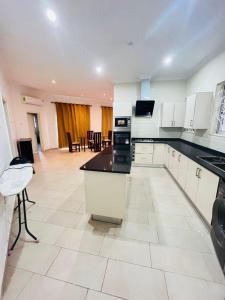 a kitchen with white cabinets and black counter tops at Teiman Apartments in Teiman