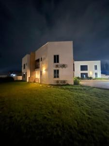 a large white building on a field at night at Teiman Apartments in Teiman