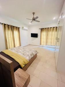 a bedroom with a bed and a ceiling fan at Teiman Apartments in Teiman