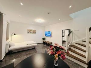 a living room with a couch and a table with flowers at Apartmenthaus Döbeln Zentrum in Döbeln