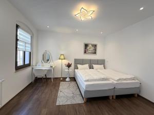 a white bedroom with a bed and a desk at Apartmenthaus Döbeln Zentrum in Döbeln +108 photos