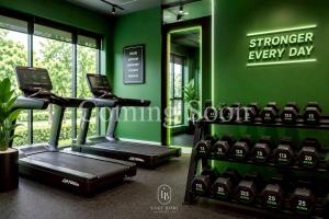 a gym with a treadmill and a green wall at Loei Buri Hotel by Alphatel in Ban Tha Phae