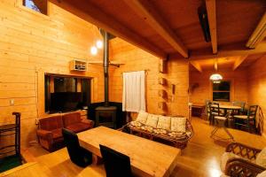 a living room with a table and a fireplace at ログハウス那須ハイグランド in Nasu