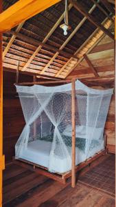 a bed in a wooden room with a net at BRIGHT Guest Hause in Besir +31 photos
