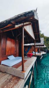 a bed on a dock in the water at BRIGHT Guest Hause in Besir