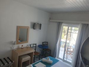 a room with a bed and a desk and a mirror at Stefos Rooms in Galissas