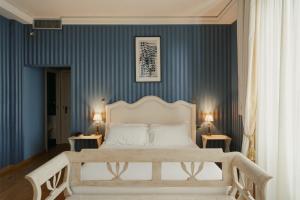 a bedroom with a white bed and blue walls at Hotel Palazzo Guiscardo Pietrasanta in Pietrasanta +197 photos
