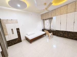 a bedroom with a bed and a chair in it at Ansh Bunglow in Belgaum