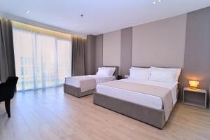 ein Hotelzimmer mit zwei Betten und einem Schreibtisch in der Unterkunft E-88 Hotel in Tirana + 17 Fotos