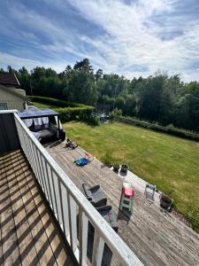 a deck with chairs and a yard with a lawn at Enebolig i Larkollen in Moss