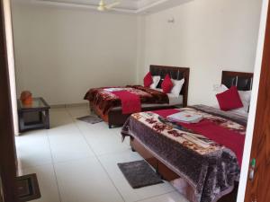 a room with two beds in a room at Hotel Shri Mahavir in Chamoli
