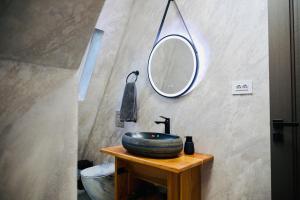 a bathroom with a sink and a mirror on a table at A Frame Poalele Transalpinei in Novaci-Străini +53 photos