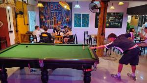 a young boy playing pool in a restaurant at Blanco Central in Phi Phi Islands