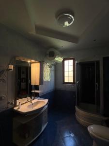 a large bathroom with a sink and a toilet at Vila Mani in Durrës +9 photos