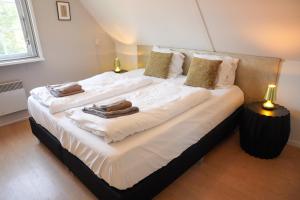 a bedroom with two beds with towels on them at De Noteboom 6-persoons, verwarmd privé zwembad, hottub, overdekte lounge met haard, panorama sauna, sunshower, luxe, wifi in Lievelde +65 photos