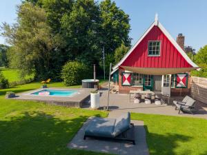 a red barn with a pool in the yard at De Noteboom 6-persoons, verwarmd privé zwembad, hottub, overdekte lounge met haard, panorama sauna, sunshower, luxe, wifi in Lievelde