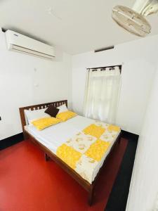 a bedroom with a bed with yellow and orange pillows at Vilayara Heritage Retreat -Kozhikode in Kunnamangalam
