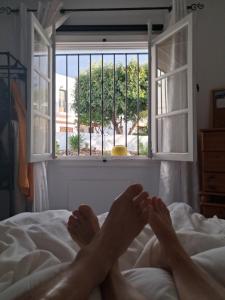 a person laying on a bed looking out a window at Apartament Maria F in Mojácar +7 photos